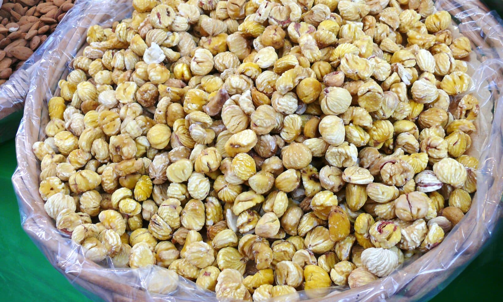 Castanhas secas e descascadas, amontoadas num cesto de mercado