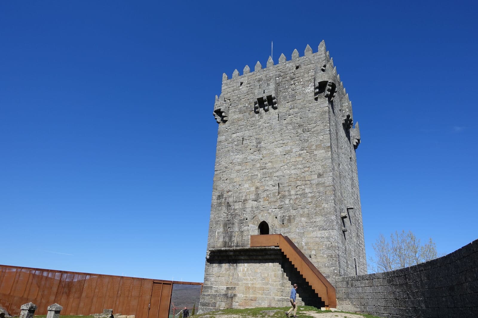Torre de menagem do castelo de Montalegre, em granito, com a escada de acesso e céu azul