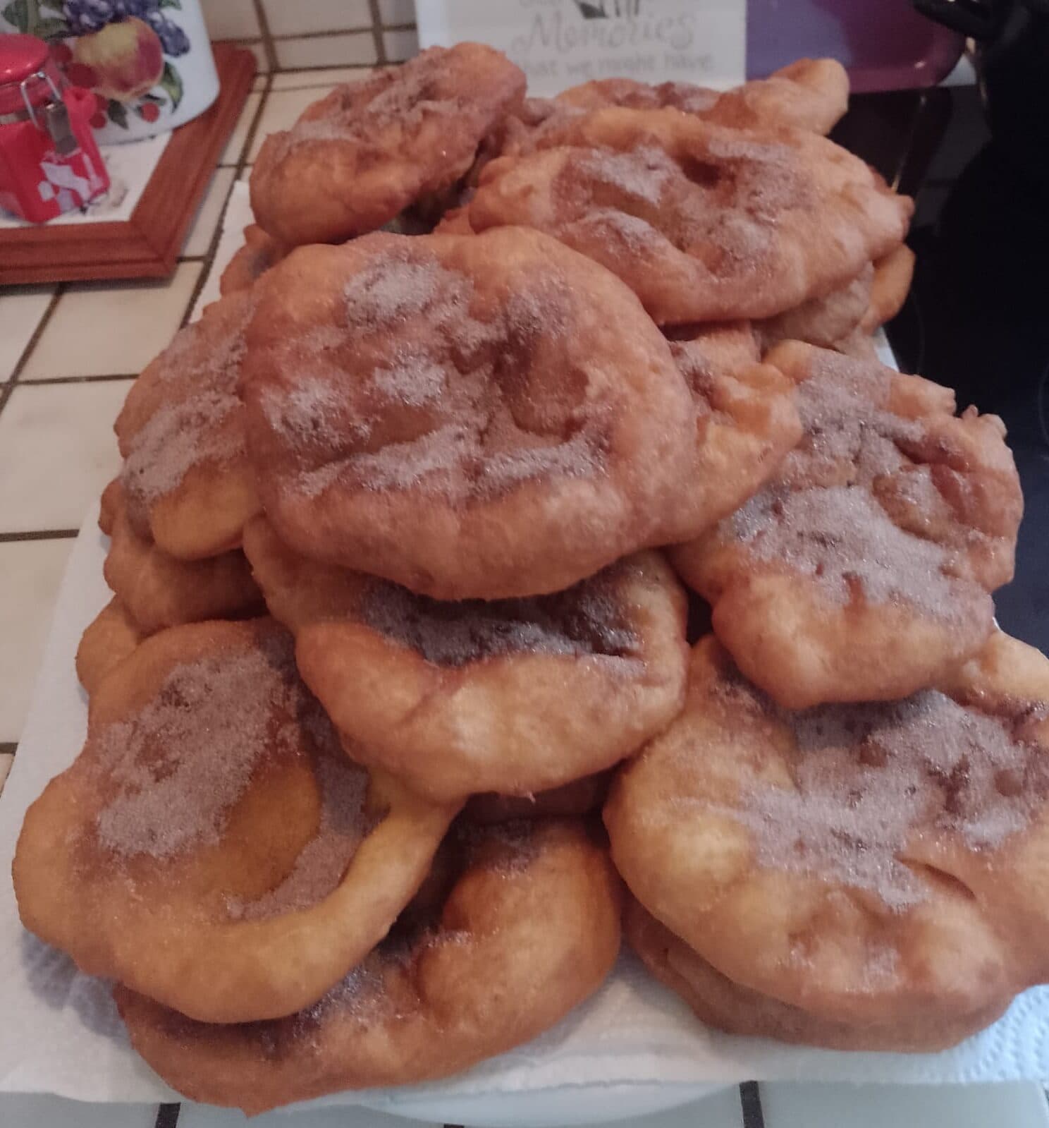 Pilha de filhós fritas, douradas e polvilhadas com açúcar e canela