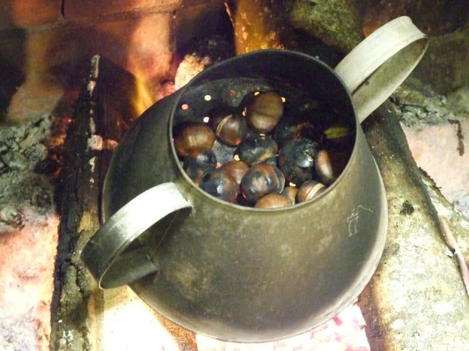 Castanhas a assar numa caçarola furada, sobre a brasa