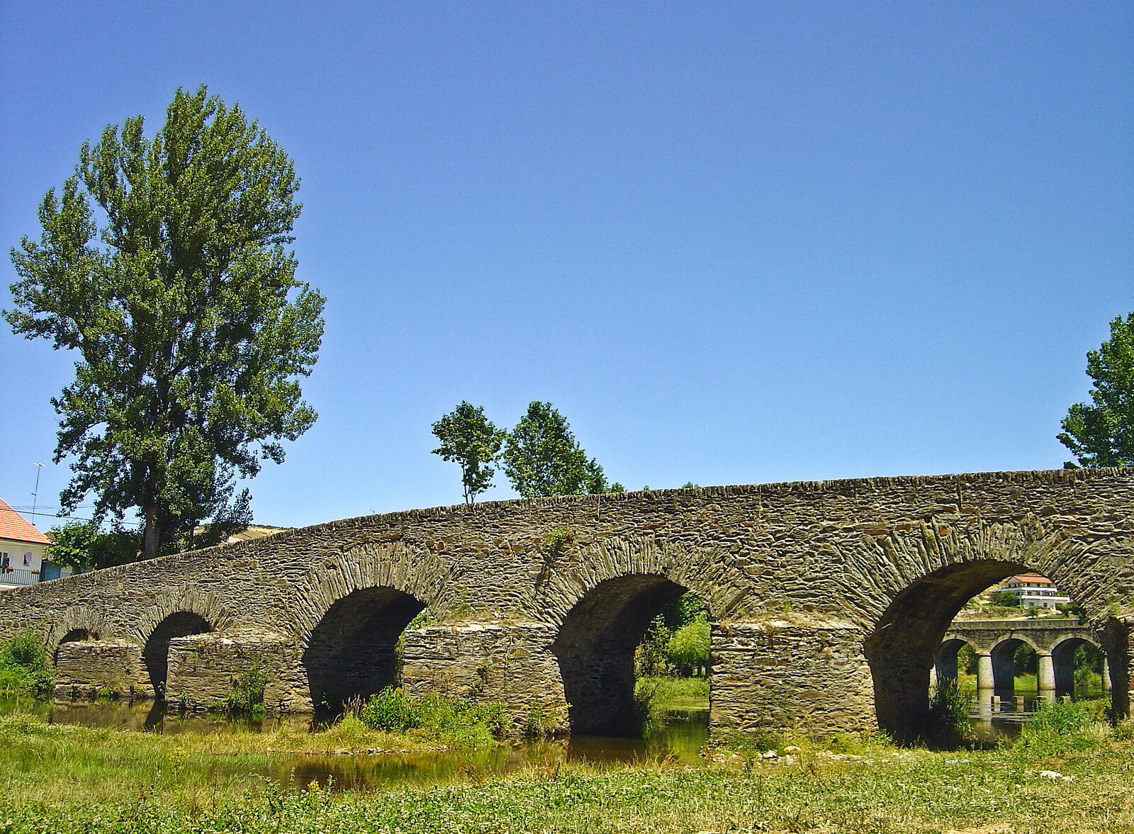 Ponte velha de Gimonde, em xisto, com arcos de volta perfeita sobre o rio, e a ponte nova ao fundo