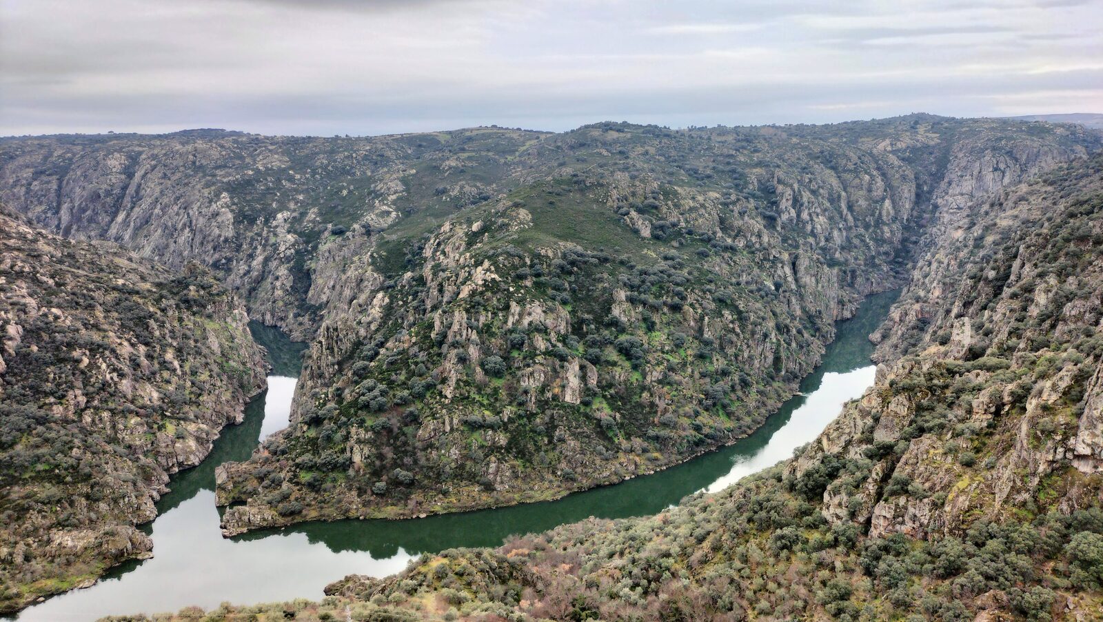 O rio Douro numa curva apertada entre encostas de granito cobertas de mato, visto do alto, junto a Picote