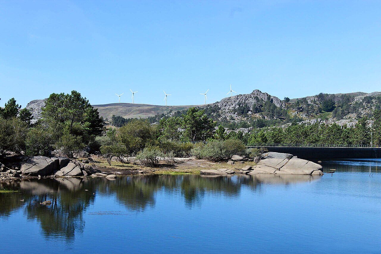 Albufeira da barragem Cimeira do Alvão, com rochedos de granito e árvores na margem